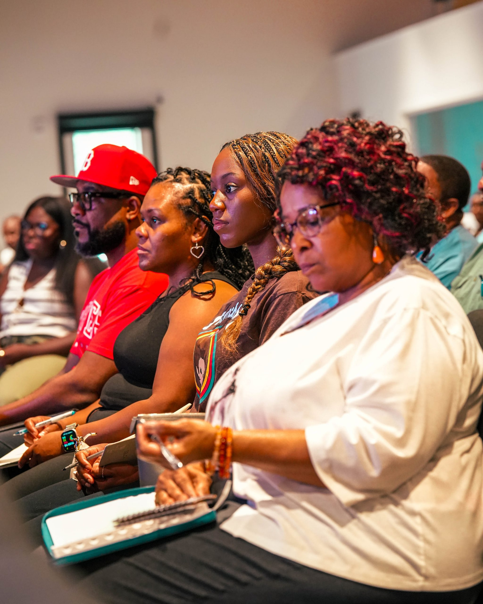 Adults seated in rows taking notes during a session.