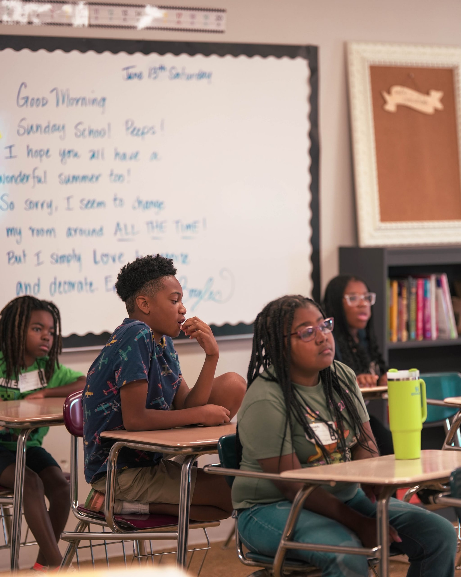 Students seated at classroom desks listening during a lesson.